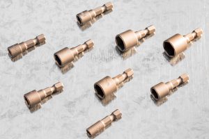 Zestaw komponentów technicznych ułożonych na blasze, ilustrujący profesjonalne elementy metalowe na zamówienie wykonane z wysokiej jakości stali